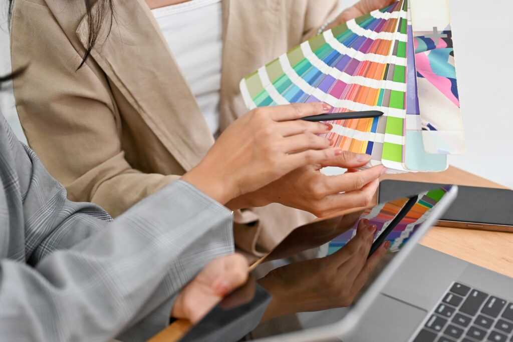 Two of a graphic designers are discussing and planning the web colour for their project together.